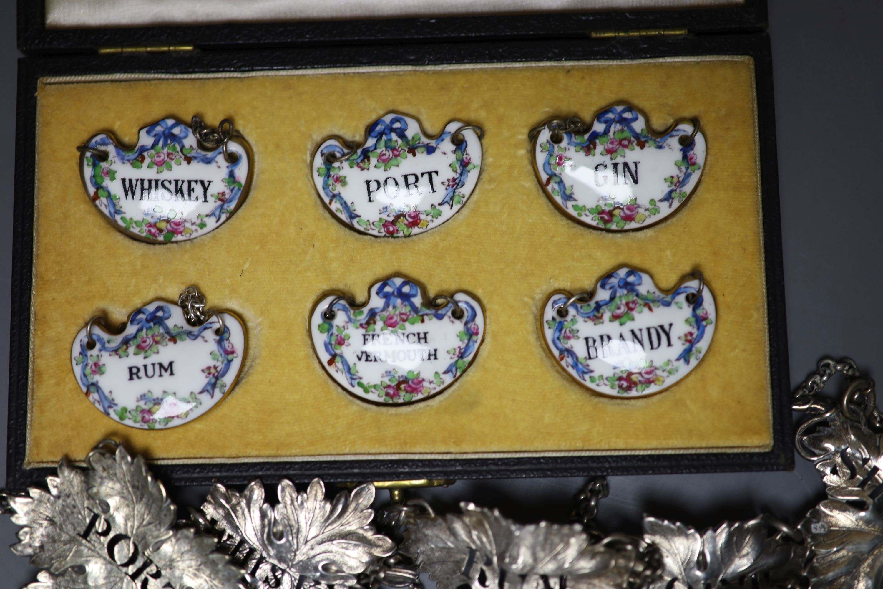 A set of four Victorian silver leaf shaped wine labels, London, 1874, 64mm, one other Victorian silver wine lable, a plated wine label and a set of six ceramic wine labels by Goode & Co.